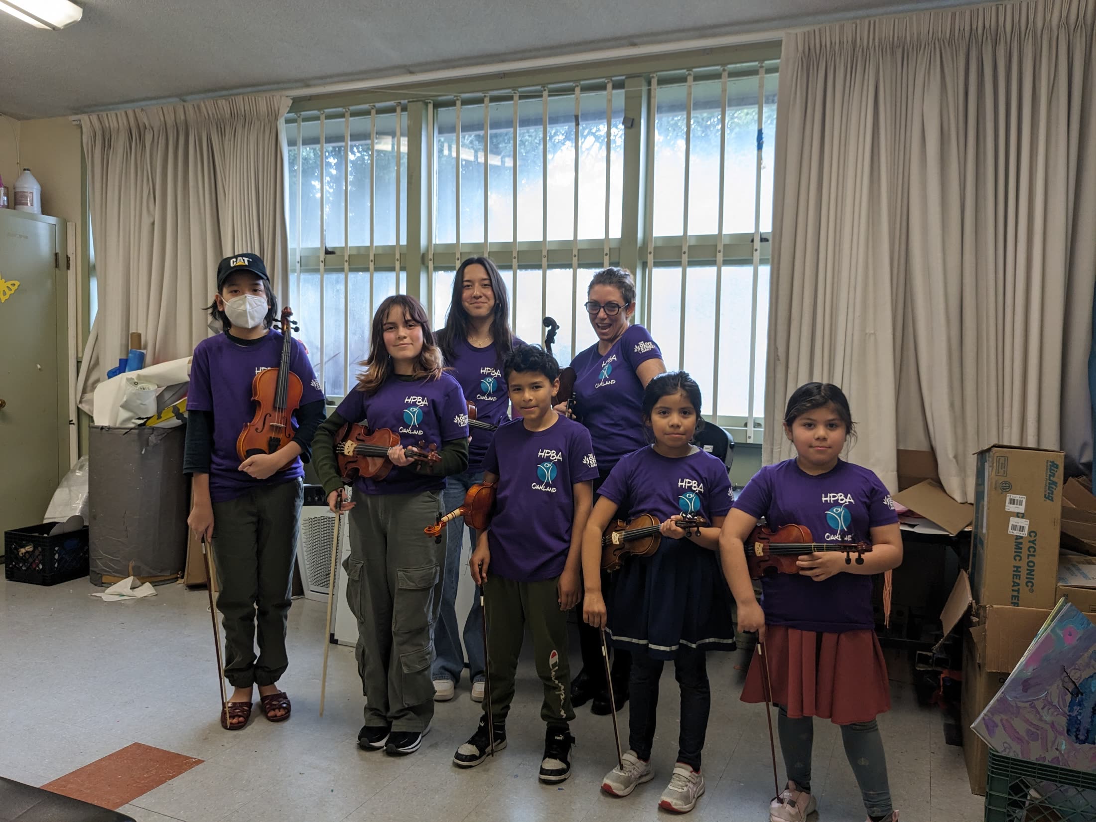 Harmony Project Oakland students holding violins
