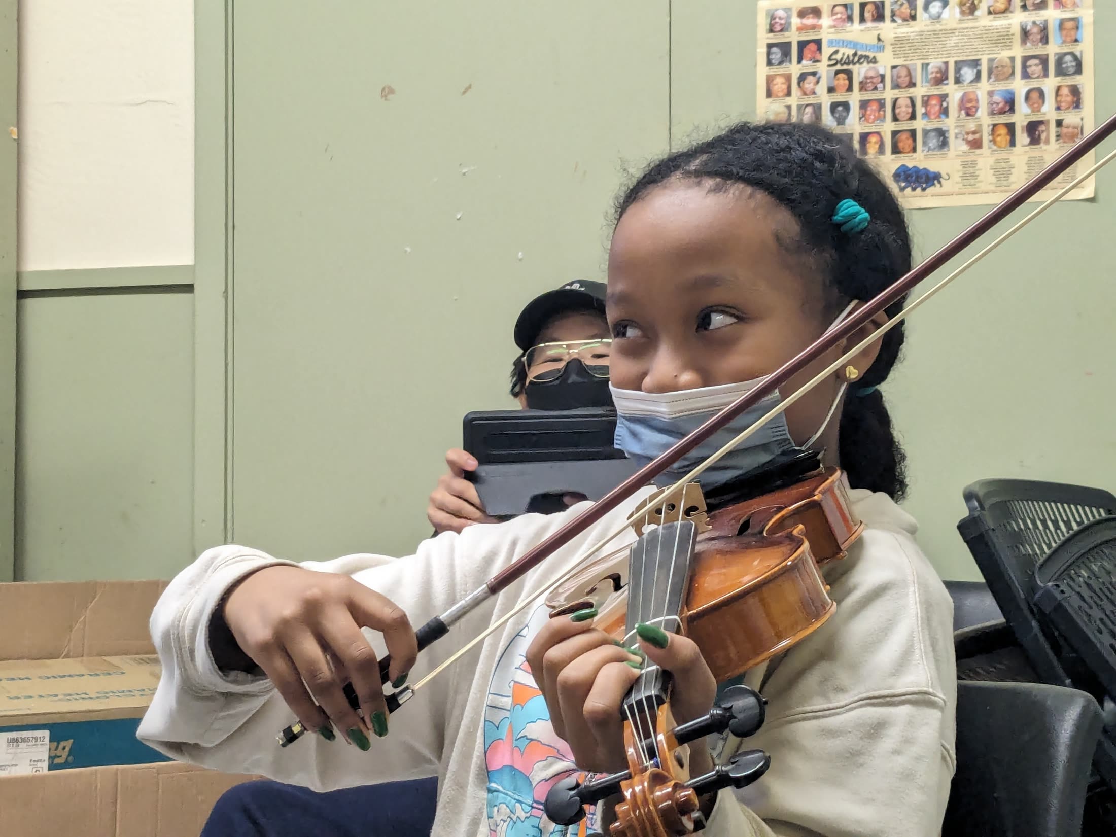 A student smiling while holding a violin